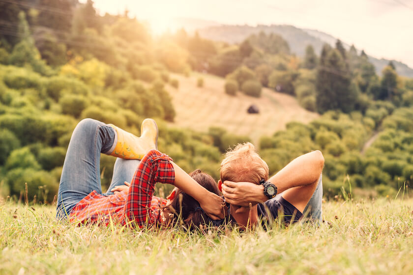 A couple lie on the grass and look at the view across the hillside, reflecting on reflecting on their journey into marriage.
