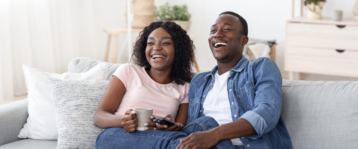 Couple sitting on the sofa watching tv creating their own way of doing things.