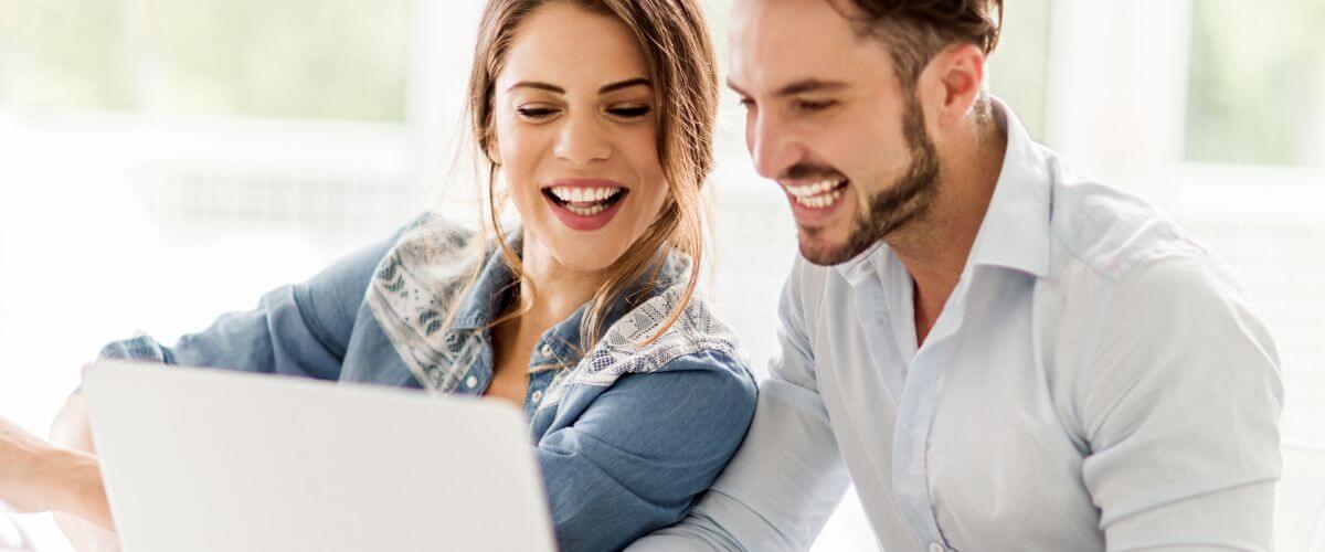 Newlywed couple look at a laptop learning and building the blocks of their partnership.