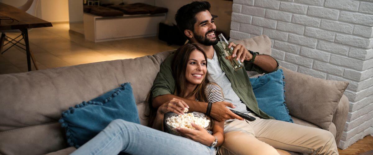 Couple watch tv together on the sofa experiencing the little realisations that shape their life.