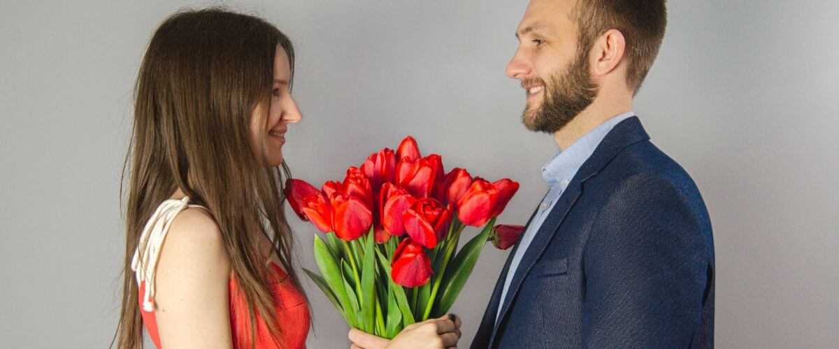 Husband gives his wife red tulips representing a common behaviour.