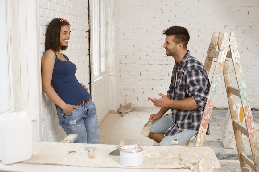 Couple talk as they decorate their new home together discussing how to compromise