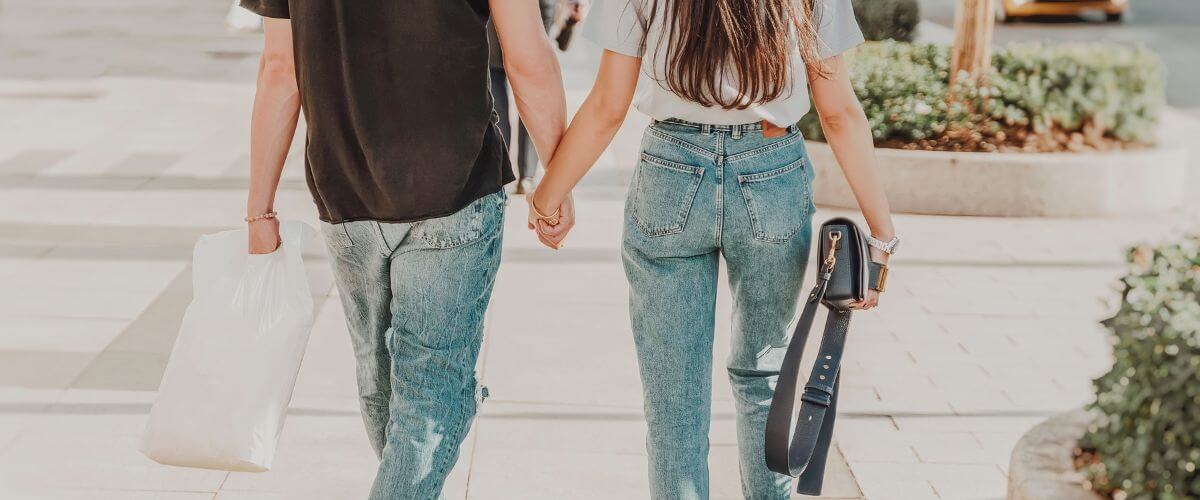 Couple hold hands as they shop learning skills that build a life together.